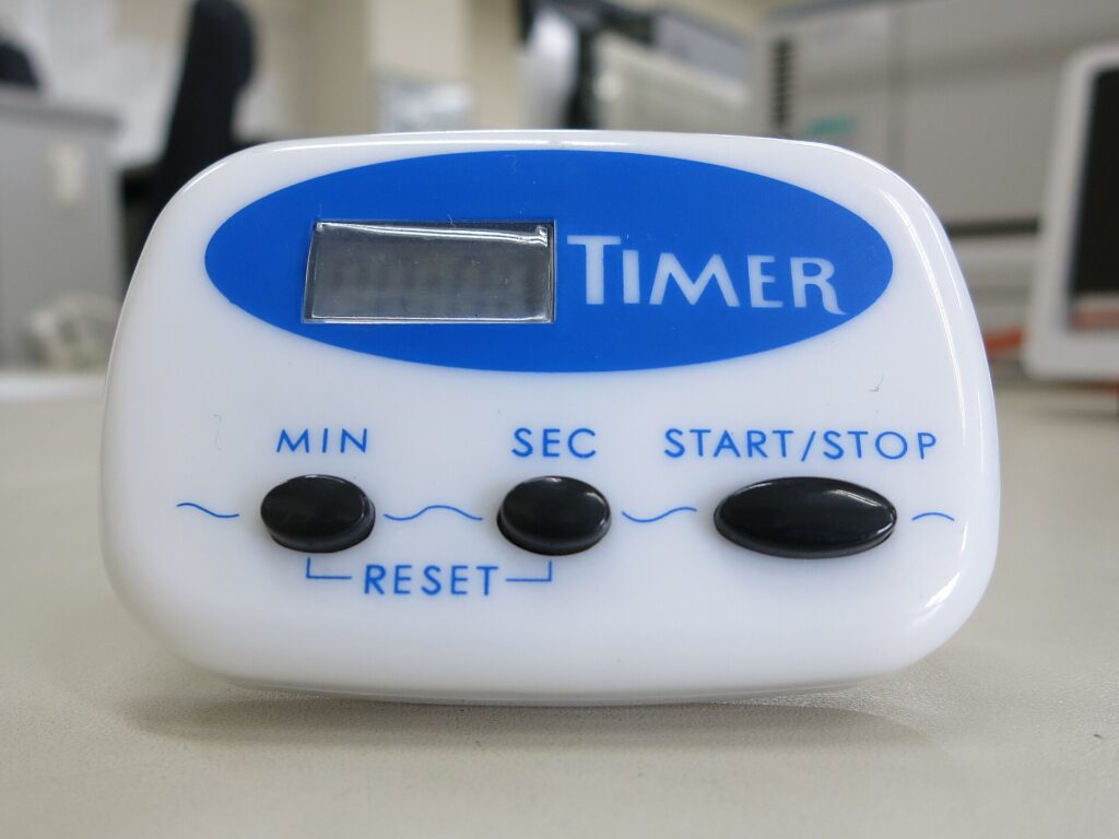 Mechanische Küchenuhr steht auf einer Arbeitsplatte neben einer weißen Tasse