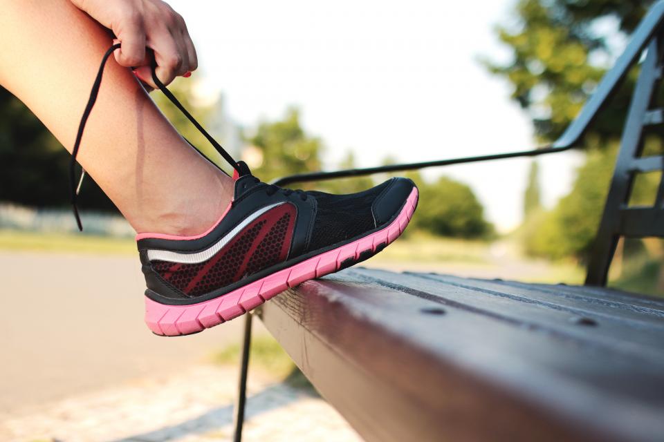 Ein Paar Laufschuhe steht auf einer Fußmatte neben einer geschlossenen Wohnungstür