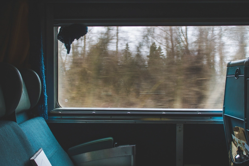 Leere Sitzreihen in einem Nahverkehrszug mit Blick auf das Fenster am Morgen