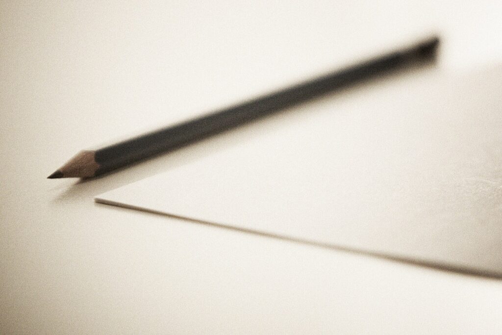 Leeres Blatt Papier quer auf einem Tisch mit einem Bleistift am Rand