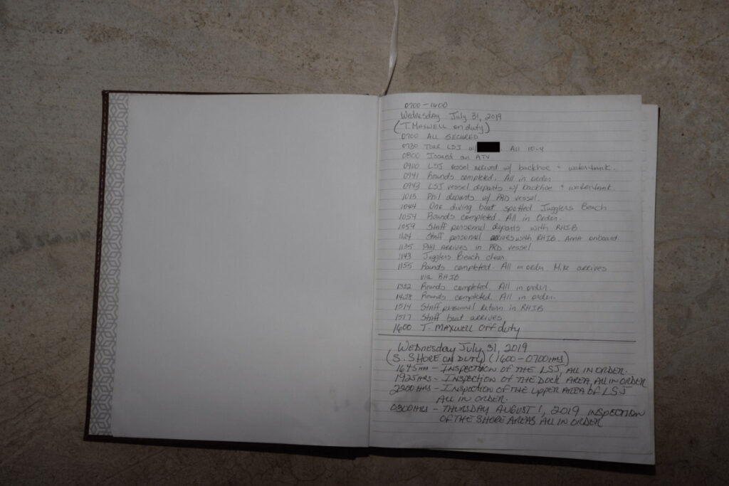 Aufgeschlagenes Notizbuch mit handschriftlichen Zeilen und einem Stift auf einem Holztisch
