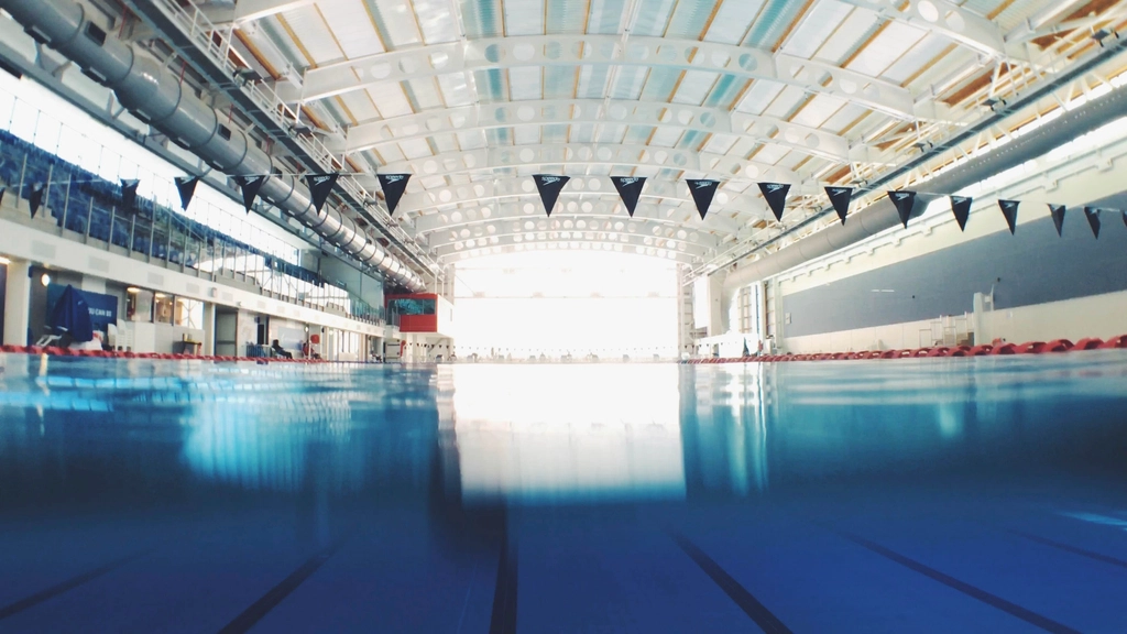 Ruhiges Schwimmbecken mit Bahnenmarkierungen in einer leeren Schwimmhalle